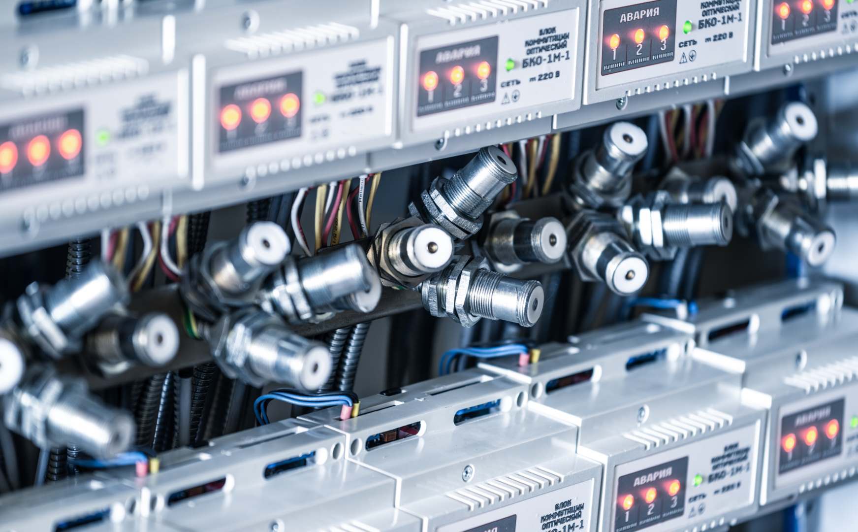 Close-up numerous metal plugs hang next to instrument panels at a factory for the production of specialized equipment. Industrial Manufacturing Concept